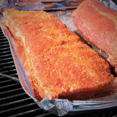 Ribs sitting on foil dusted with the rub ready to cook.