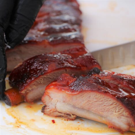 Ribs being sliced into one bone serving sizes.