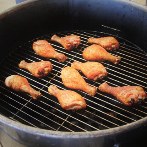 Chicken Drumsticks cooking in a round smoker.