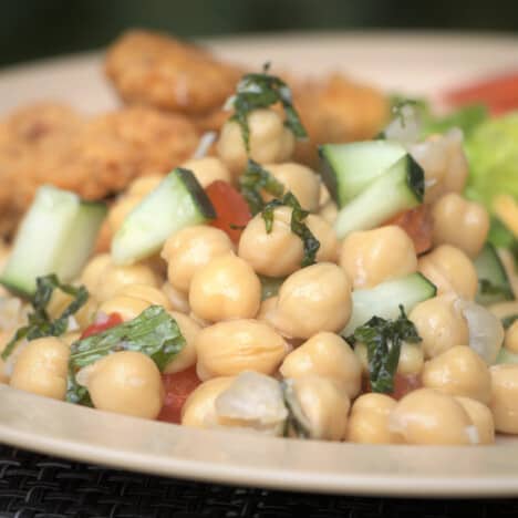 Close up of chickpea salad on a tan camp plate.