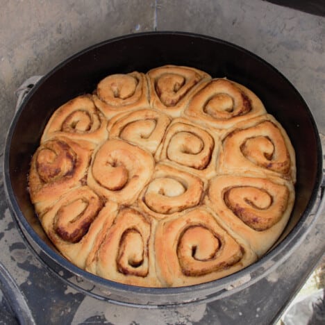 Looking into a Dutch oven to see golden brown baked sweet rolls.