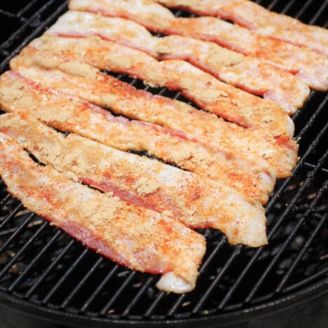 Rashers of bacon with brown suugar on them laid side by side on a waire rack.