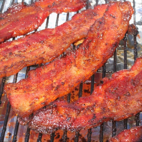 Cooked strips of bacon candy cooling over a foil covered bench.