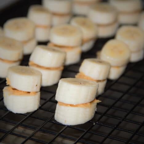 A rack covered in sandwiches of banana with peanut butter in between.