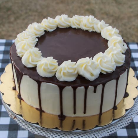 Looking down on a chocolate coconut cake with chocolate ganash and coconut frosting florets added.