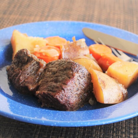 A blue camp plate with a serving of beef pot roast.