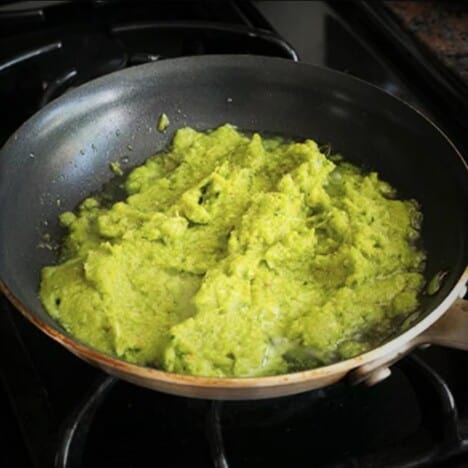 The bright green-yellow marinade is being cooked in the skillet.