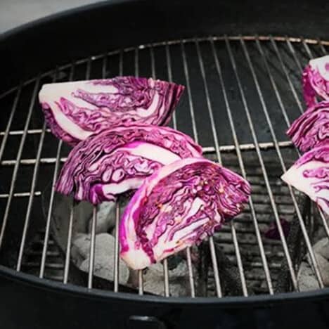 Wedges of red cabbage on a grill.
