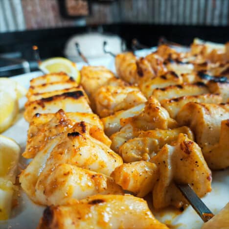 Looking accross grilled calamari skewers.