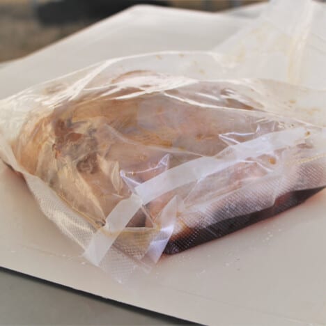 A plastic ziplock bag with chicken marinating in it.
