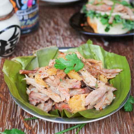 Shredded pork butt is served on a banana leaf.