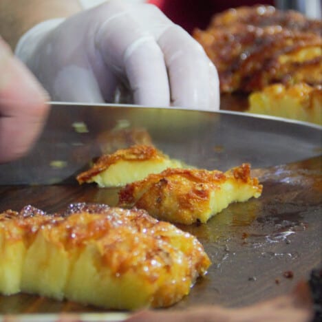 Strips of grilled pineapple bing sliced into bite sized pieces.