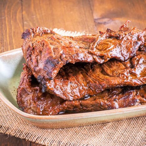 Two pieces of grilled skirt steak resting on a plate.