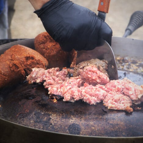 On the hot discada the raw ground pork is being broken up with the raw chorizo in the background.